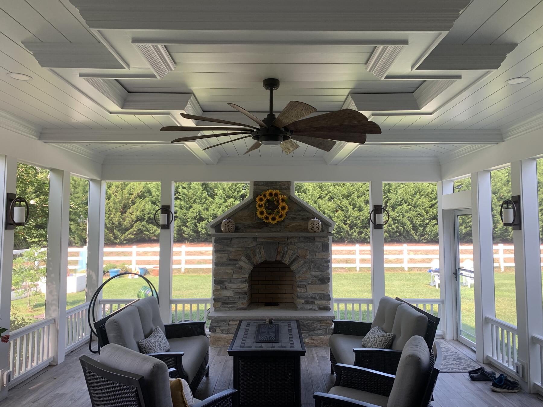 Screened porch interior with stone fireplace and coffered ceiling in Lewes, DE